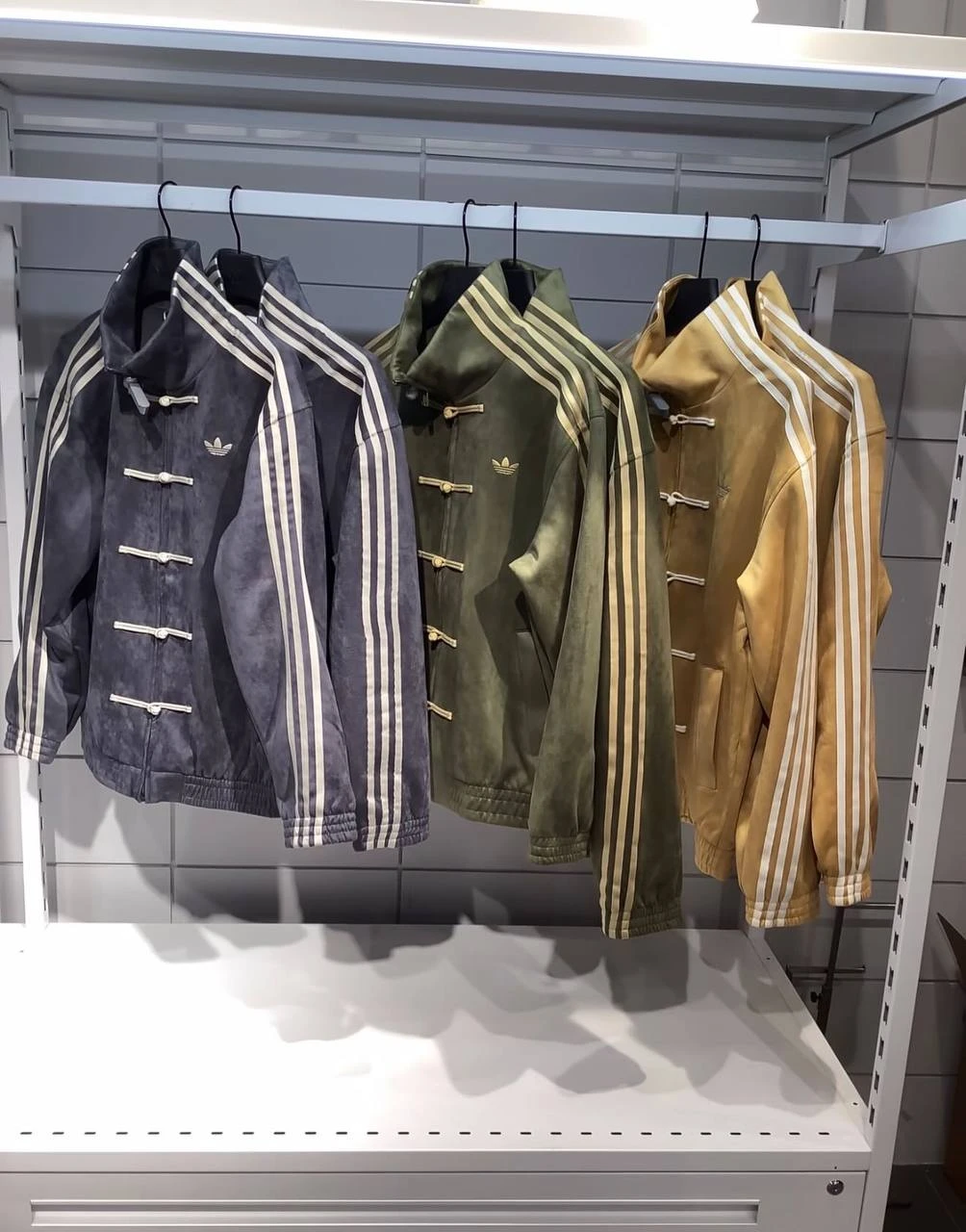 Adidas Originals Chinese Track Top на вешалках в магазине в трёх расцветках — графитовой, оливковой и горчичной